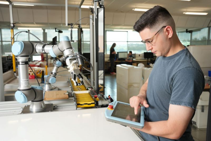 Robotic arm and operator at conveyor belt 