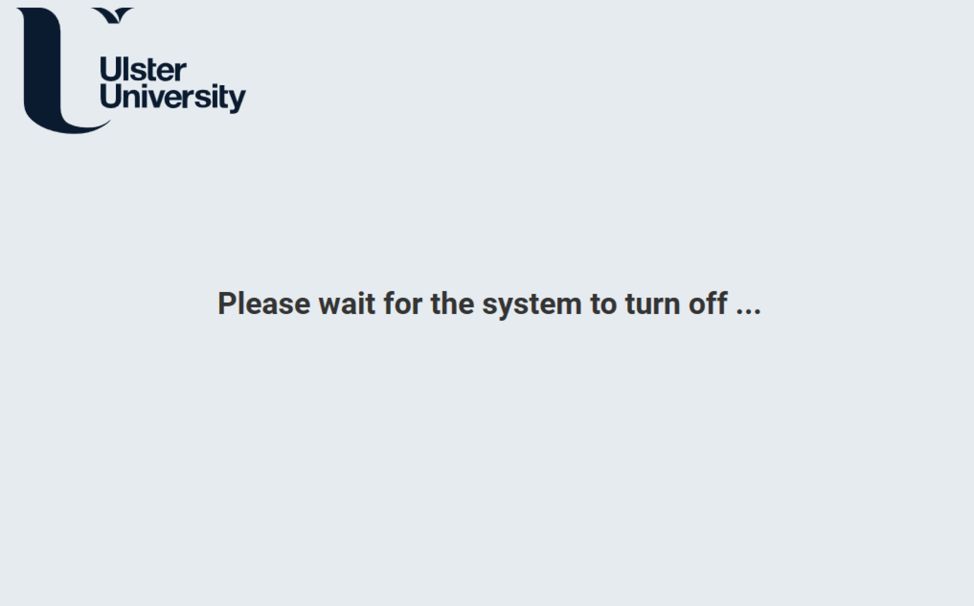 Ulster University shutdown screen displaying the Ulster University logo and the message “Please wait for the system to turn off...”, indicating that the room system is powering down.