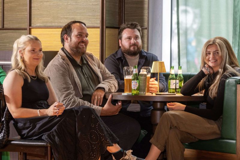 Group of guests, sitting around a table filled with beverages, being engaged by Ardmore event panel.