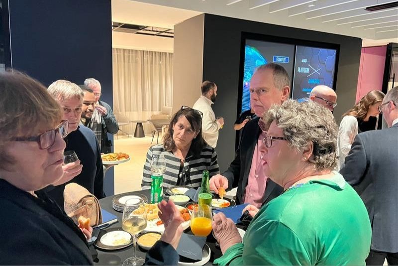 Group of attendees networking with each other around a table at the \'Where AI Meets Leadership\' event