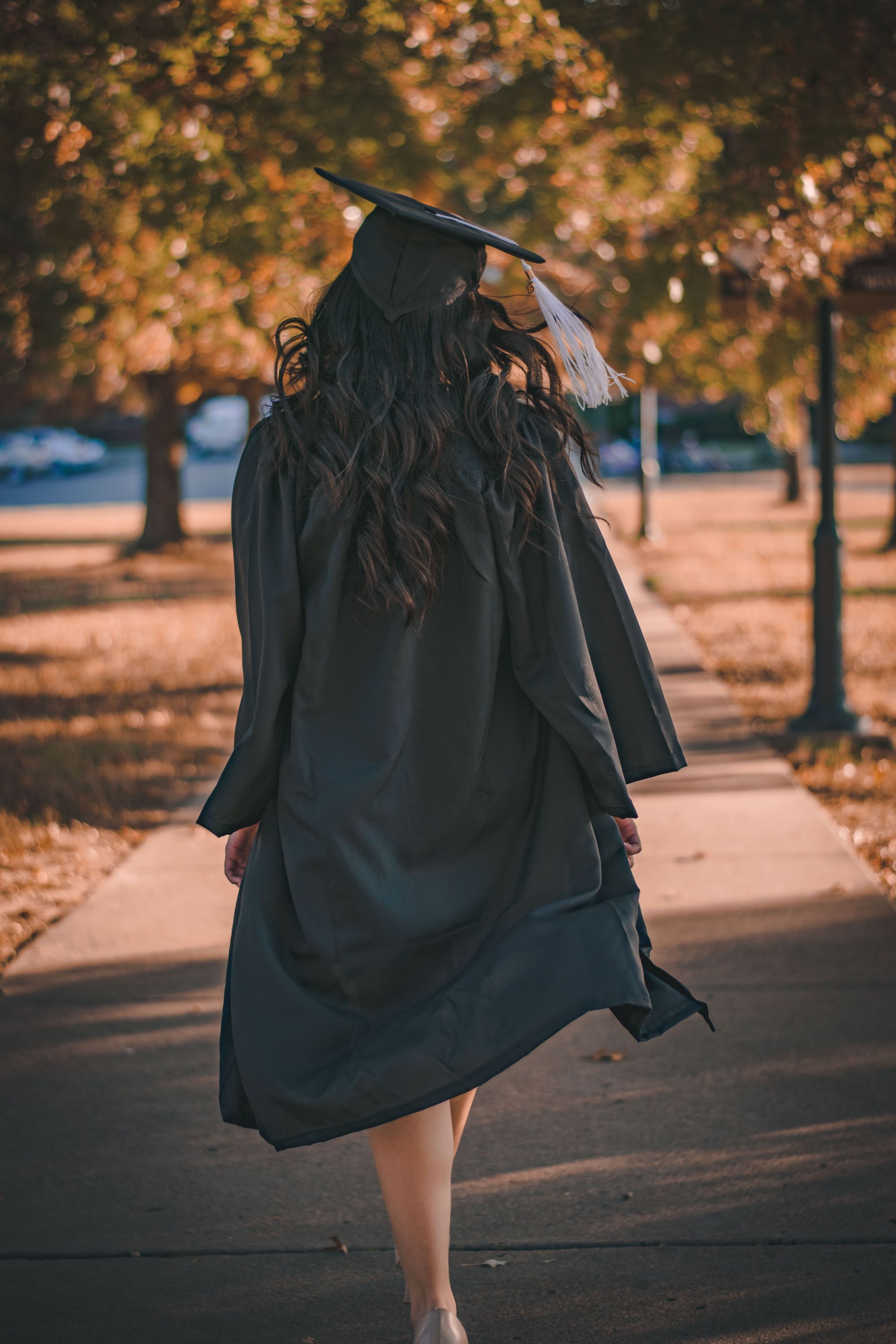 Walking in graduation gown.