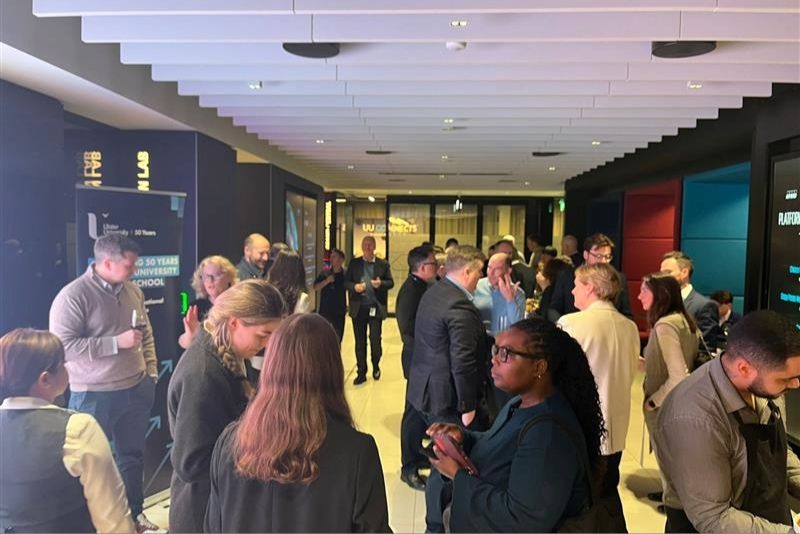 Group of attendees networking with each other around a table at the \'Where AI Meets Leadership\' event