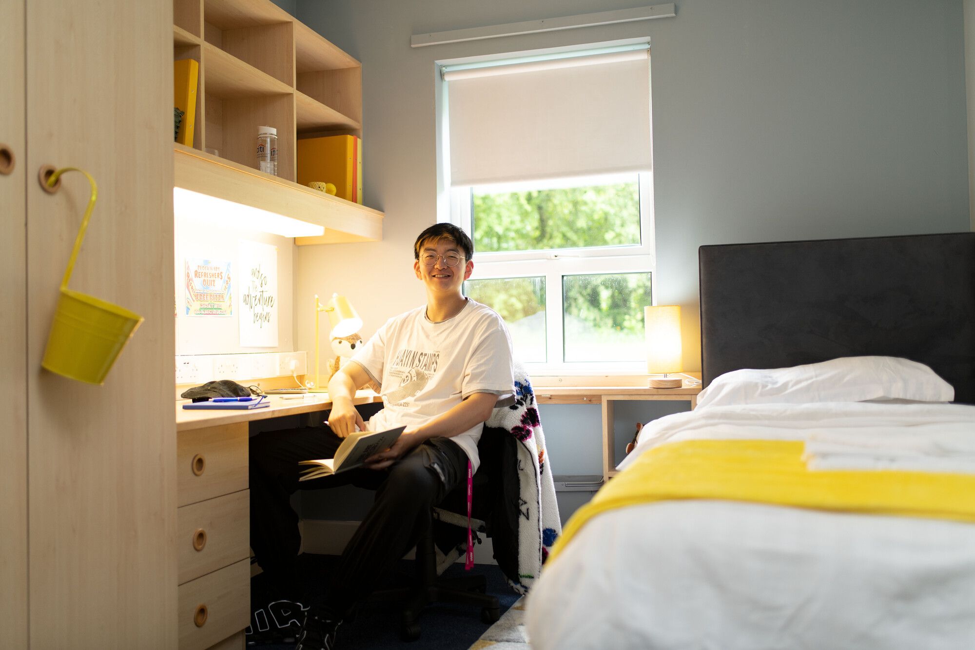 Student sitting at his desk in a halls of residence bedroom