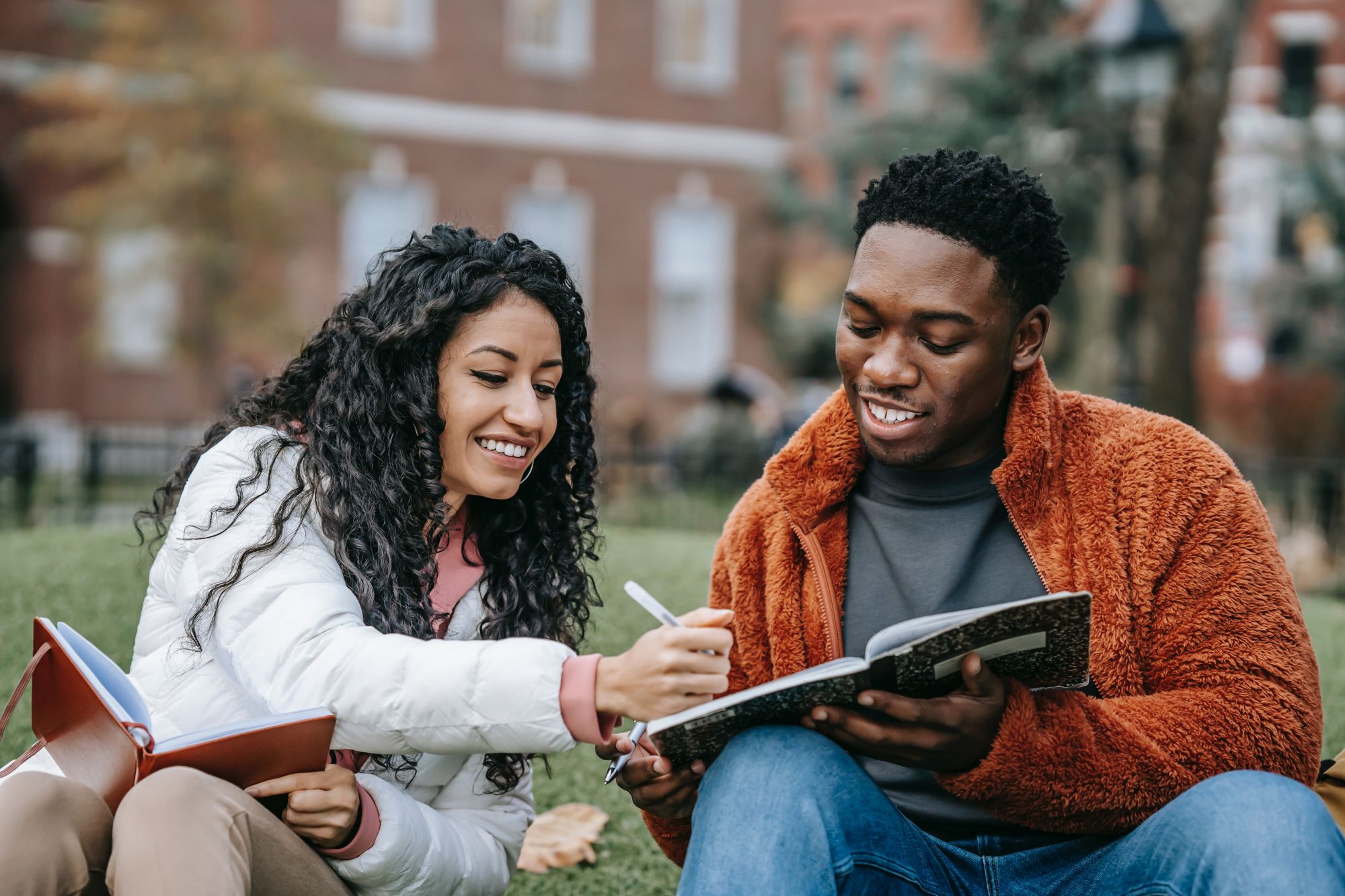 2 friends reading outside their university building