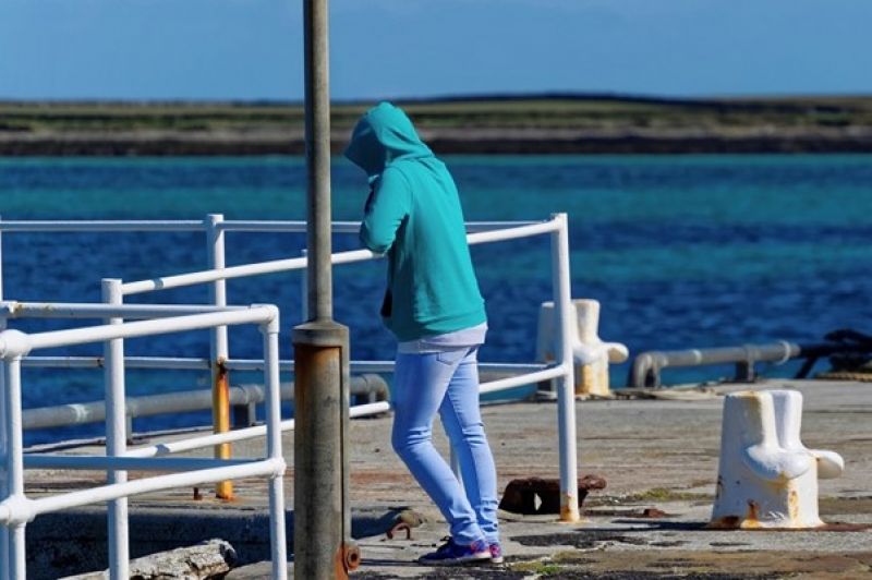 young person in hoodie on pier