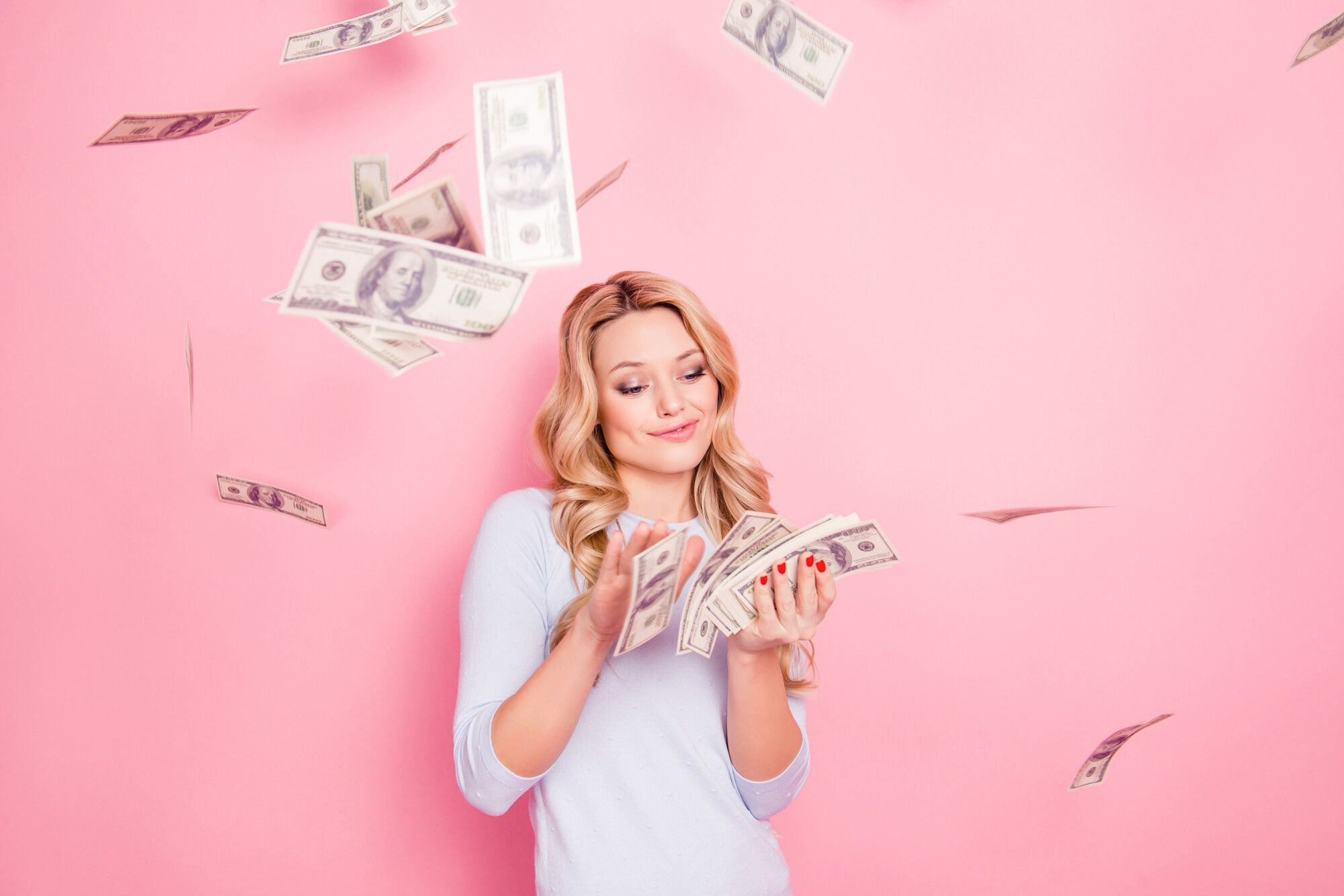 Blonde woman throws bank notes into the air