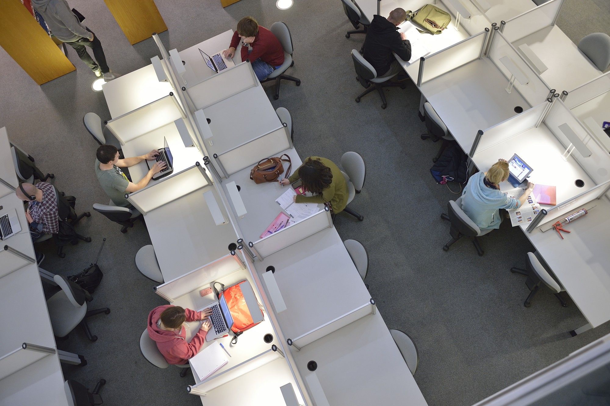Overhead photo of students working at desks in the library