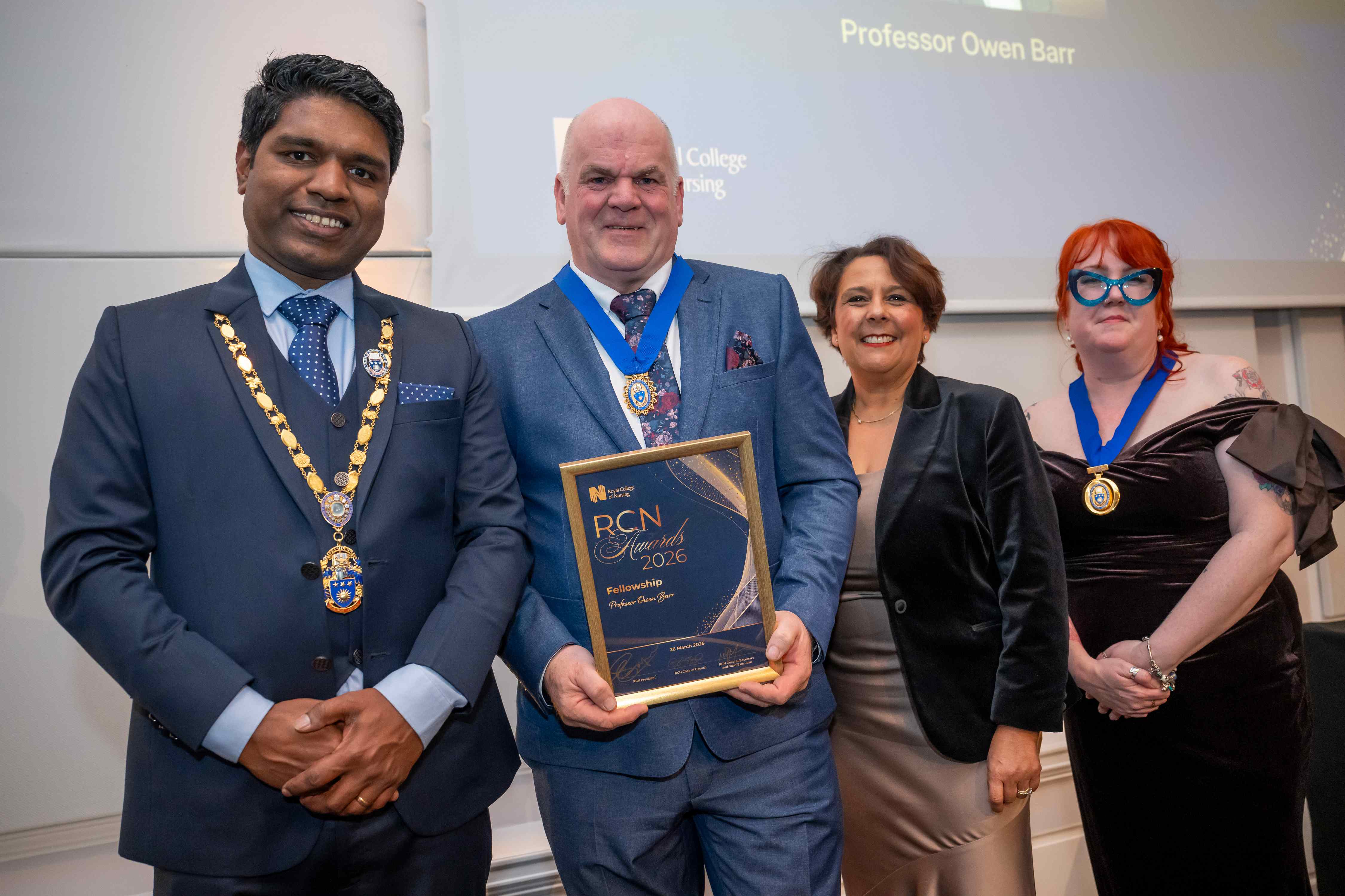 Owen Barr holding his RCN Award, standing with three members of the RCN
